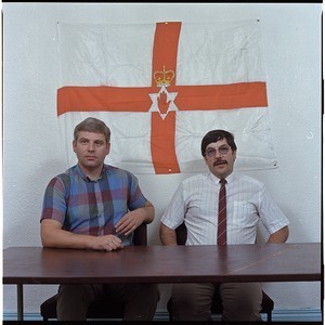 John McMichael and Andy Tyrie, taken in front of the Ulster flag