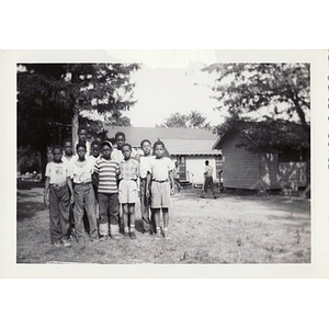 A group of campers pose in front of the cabins at Breezy Meadows Camp