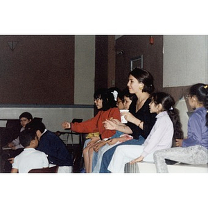 Woman and children sitting in the audience at a Teen Empowerment Program event at the Jorge Hernandez Cultural Center.