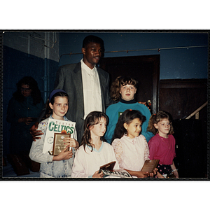 Former Boston Celtic Reggie Lewis posing for a group picture with five girls at a Kiwanis Awards Night