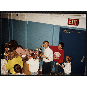 Jerry Steimel, Charlestown Boys and Girls Club director, posing with a girl behind a table with many gifts