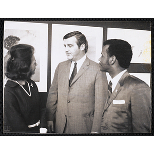 Frederick J. Davis, at center, conversing with Mrs. Frederic Church and an unidentified man at the Boys' Clubs of Boston Tri-Club Art Exhibit at the Museum of Science