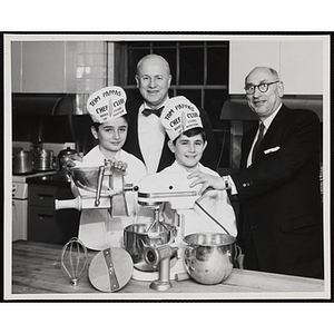 Two members of the Tom Pappas Chefs' Club, Executive Director of Boys' Club of Boston Arhtur T. Burger (center) and Chairman of Chefs Club Committee Joseph B. Margolis (right) accept the gift of a KitchenAid mixer