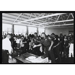 Boston Police officers perform with microphones with a DJ for children during a public relations event