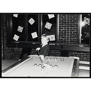 A Boy playing a game of bumper pool