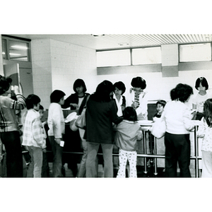 Chinese American women and children stand in line to get food at the 29th anniversary celebration of the People's Republic of China held at the Josiah Quincy School