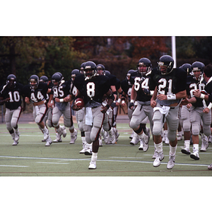 Northeastern football players take the field for a game