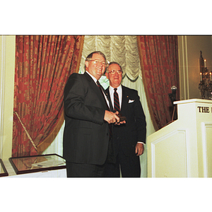 Chairman George Matthews passes the gavel to Neal Finnegan at a Corporation meeting