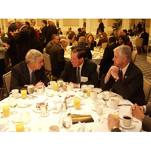 Three men talking at table during the College of Business Administration's CEO Breakfast Forum