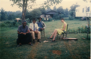 Charlie Hill, two unidentified men, and Marjorie Merrill (l. to r.) seated on a lawn