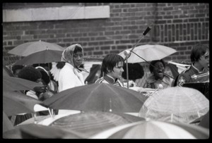 Close-up of crowd, with umbrellas, awaiting the arrival of Gerald Ford to dedicate the Old Great Falls Historic District as a national historic landmark