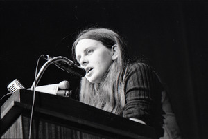 Bernadette Devlin McAliskey at the podium during a talk at Northeastern University