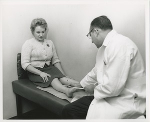 Doctor measuring Mrs. Frances Marsala's leg on an exam table