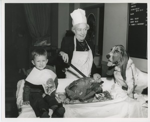 Young client with older woman and dog carving a turkey