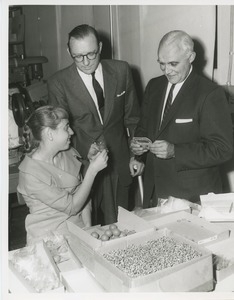 Marsha Munies demonstrating assembly work for Orin Lehman and an unidentified onlooker