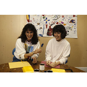 Two women holding an art project