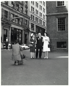 Unidentified man photographing Mary Collins; Mark Bortman, Chairman of the Civic Committee of the People-to-People Program; amd unidentified woman in front of the Old State House