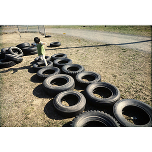 Child playing with tires on a playground