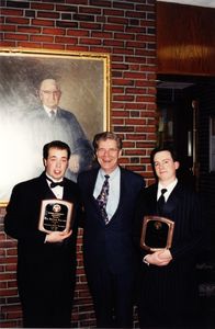 Suffolk University Athletics Director James E. Nelson poses with two students and their awards at the Student Government Awards ceremony