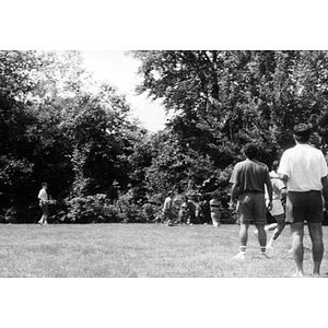 Inquilinos Boricuas en Acción employees playing a game on a lawn during a staff outing.