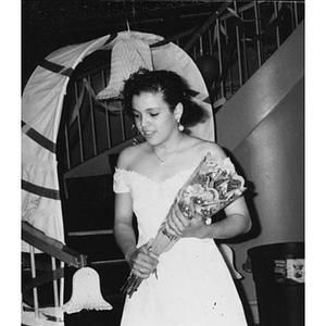 Teenage girl in a party dress holding a bouquet of flowers.