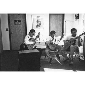 Three men playing guitars in the Inquilinos Boricuas en Acción offices.