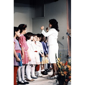 Woman conducting children's choir at the opening of the Villa Victoria Cultural Center.