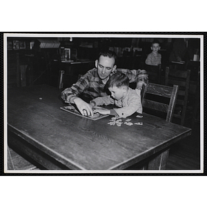 A man and a boy assemble a puzzle at a Father and Son Night event