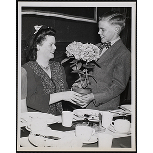 William Mallard presents a his mother with a potted plant during a Mother and Son Supper sponsored by the Mothers' Club