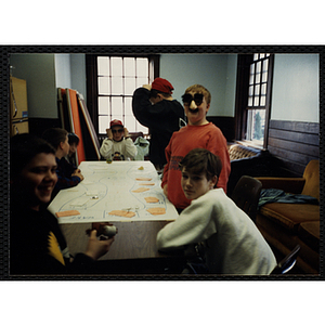 Group of children playing game at a table and wearing funny glasses