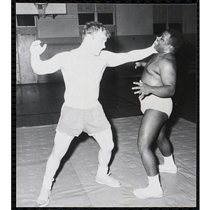 A wrestler reaches for his opponent in the South Boston gymnasium