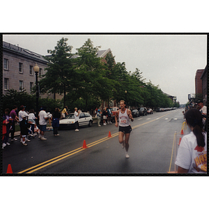 A man runs past spectators during the Battle of Bunker Hill Road Race