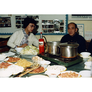 Guests at a food table during a Chinese Progressive Association event