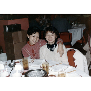Two women pose at a restaurant table during a reception for the Consul General of Guangdong Province
