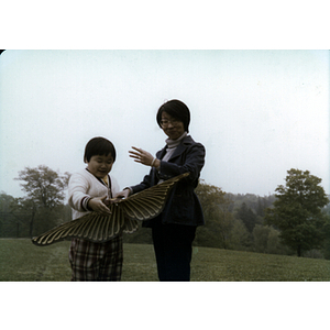 Suzanne Lee holds a butterfly kite with a young boy, during a tutoring class picnic