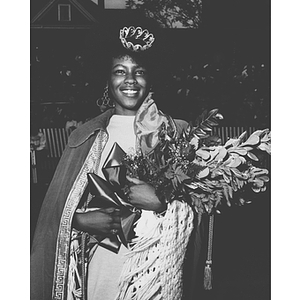 Homecoming Queen Linda Brown holds a bouquet of flowers