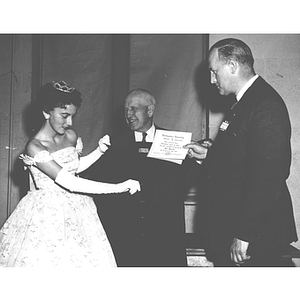 The Homecoming Queen holds up President Ell's varsity sweater presented at the Alumni Dinner