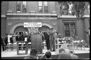 Robert F. Kennedy waving to the crowd before speaking on behalf of Democratic candidates, in front of a sign hung on the Noble County courthouse: 'Welcome Robert F. Kennedy to the turkey kingdom'