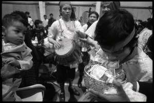 Cambodian New Year's celebration: musician using his mouth to put money into the bowl