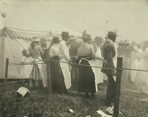 Unidentified men and women in aprons waiting in line for food