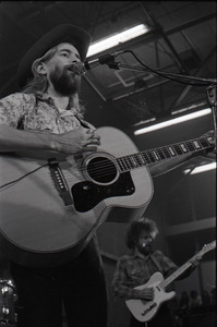 New Riders of the Purple Sage opening for the Grateful Dead at Sargent Gym, Boston University: John 'Marmaduke' Dawson playing acoustic guitar and signing with David Nelson in background