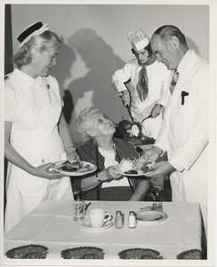 Unidentified man and woman serving Thanksgiving dinner to a client