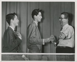 William Murphy playing ping-pong with two unidentified boys