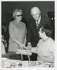 Mrs. Jeremiah Milbank and Hermann G. Place shaking hands with a client at Thanksgiving celebration