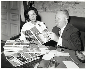 Mayor John F. Collins and an unidentified woman in his office reading the volume with Massachusetts of "American Heritage New Pictorial Encyclopedic Guide to the United States"