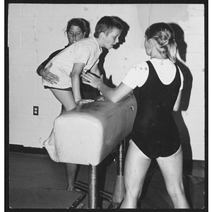 Instructors helping child with gymnastics at West Roxbury branch