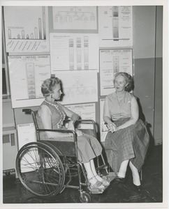 Two women, one in a wheelchair, in conversation at an administrators training group