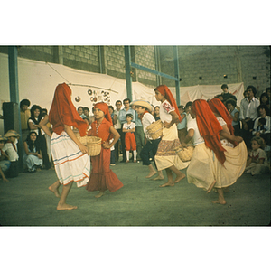 Children performing a traditional dance for a crowd of onlookers