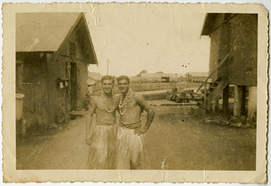 George W. Rose posing in grass skirt with friend