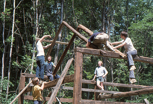 Moon Barn Raising at entrance to Hopkins Forest on 2 August 1975. Jim Skinner, Peter Jensen, unidentified, Lauren Stevens (back to camera), David Chapin Weeks, and Taber D. Allison {left to right} setting roof rafters.